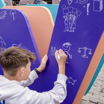 Dokumentation des Internationalen Tages der Demokratie in Konstanz ein Junge malt ein Symbol für Demokratie