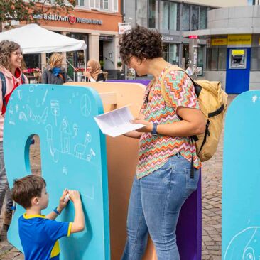 Dokumentation des Internationalen Tages der Demokratie in Konstanz ein Kind malt ein Symbol für Demokratie