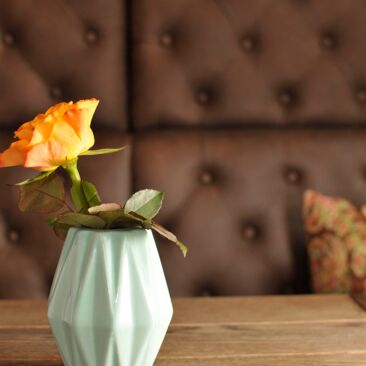 Fotografie von einer Vase mit einer Rose als Tischdekoration