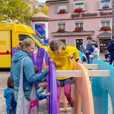 Dokumentation des Internationalen Tages der Demokratie in Konstanz mehrere Kinder spielen und malen auf der Wortkonstruktion "WIR"